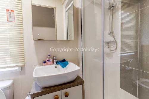 La salle de bains est pourvue d'un lavabo et d'une douche. dans l'établissement Luxury 6 Berth Caravan For Hire At Broadlands Sands Holiday Park Ref 20340bs, à Hopton on Sea