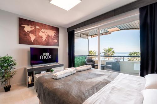 - une chambre avec un grand lit et une vue sur l'océan dans l'établissement Beachfront Studio with Stunning Sea Views, à Marbella