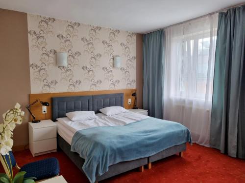 a bedroom with a large bed and a window at Hotel Orbita in Wrocław