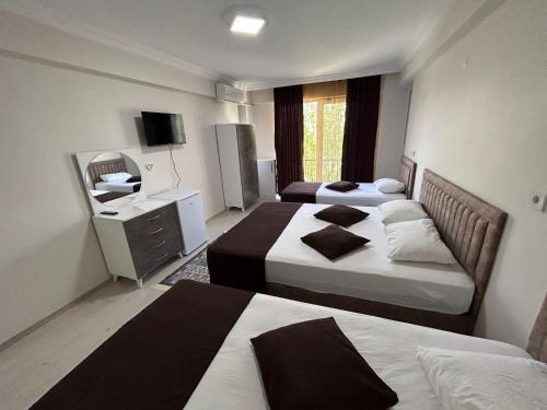 a hotel room with two beds and a television at Paradise House in Pamukkale