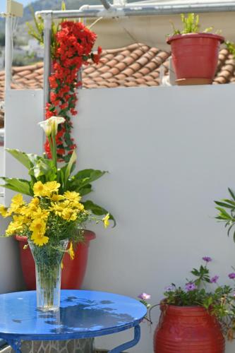 a vase of flowers on a table with flowers at Maria's House in Hydra