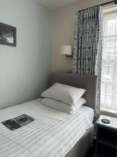 a bedroom with a bed with a book on it at The Bar Convent Guest House in York
