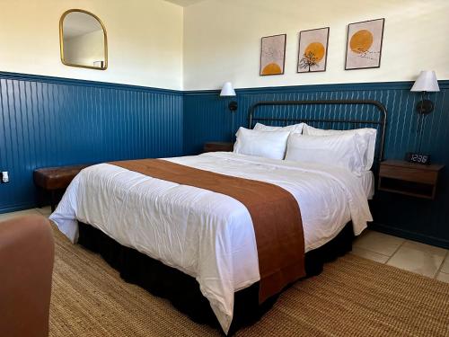 a bedroom with a large bed with blue walls at Budget Host East End Hotel in Riverhead in Riverhead