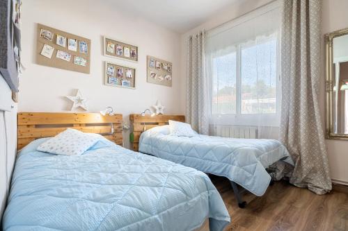 1 dormitorio con 2 camas y ventana en Villa Maravillosa, en Cunit