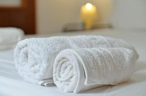 a pile of white towels sitting on top of a bed at Maria's House in Hydra