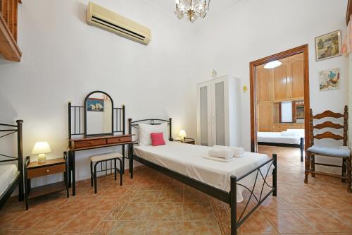 a bedroom with a bed and a table and a chair at Maria's House in Hydra