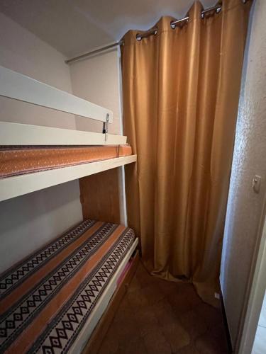 Cette chambre comprend 2 lits superposés et un rideau. dans l'établissement STUDIO SAINT MANDRIER, à Saint-Mandrier-sur-Mer