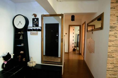 a hallway with a mirror and a clock on a wall at Apartament Lux Crialy - 75 m2 - free parking in Timişoara