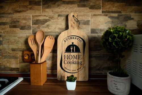 a home cooking sign on a wall with wooden spoons at Apartament Lux Crialy - 75 m2 - free parking in Timişoara