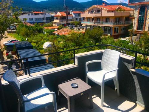 uma varanda com cadeiras, uma mesa e uma vista em Hotel Barba em Urla