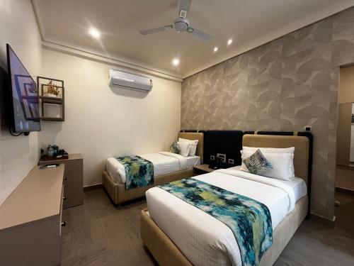 a hotel room with two beds and a tv at HOTEL JS SOUVENIR in Dehradun