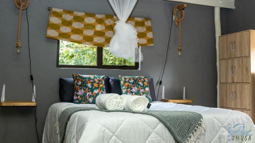 1 dormitorio con 1 cama con toallas en Lodge Umusa, en KwaMazambane