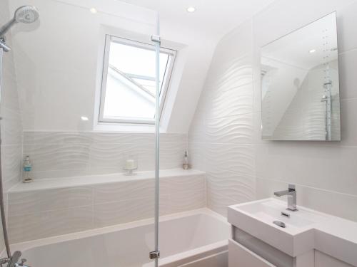 a white bathroom with a shower and a sink at The White House in Weymouth