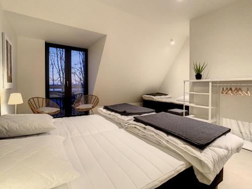 a bedroom with two beds and a window at Mooi Maaseik in Maaseik