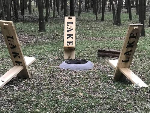 a pair of signs in the middle of a forest at Cozy Carey Bay Cottages in Grove on Grand Lake in Grove