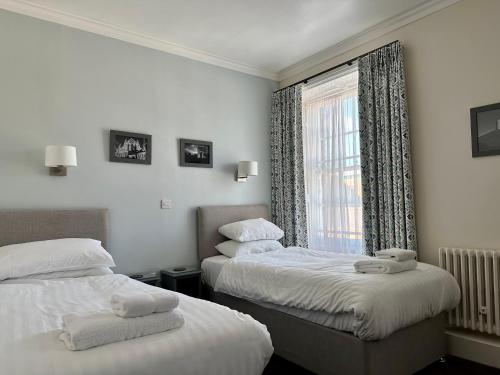 a hotel room with two beds and a window at The Bar Convent Guest House in York