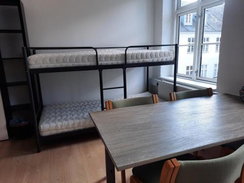 a room with two bunk beds and a table at 1- Bed Private room in apartment in Odense