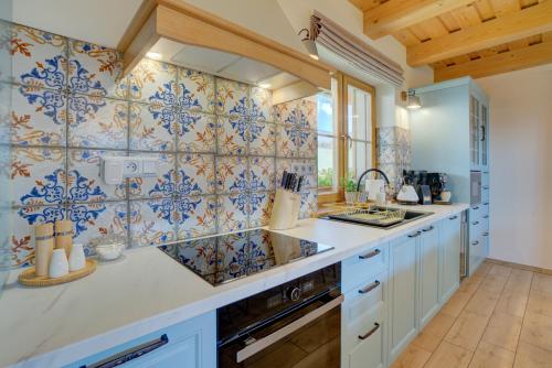 cocina con azulejos azules y blancos en la pared en Chalet West - Zuberec en Zuberec