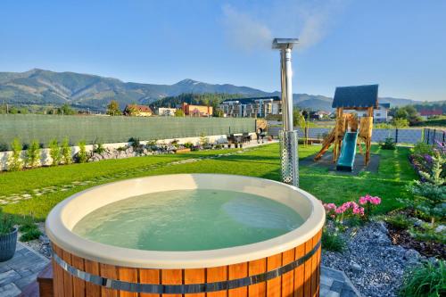 a large bath tub in a yard with a playground at Chalet West - Zuberec in Zuberec