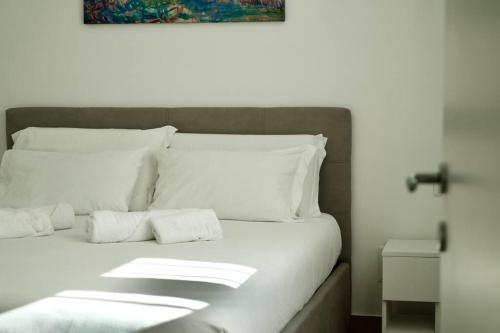 a white bed with white sheets and pillows at Residenza dei Molini Monza centro in Monza