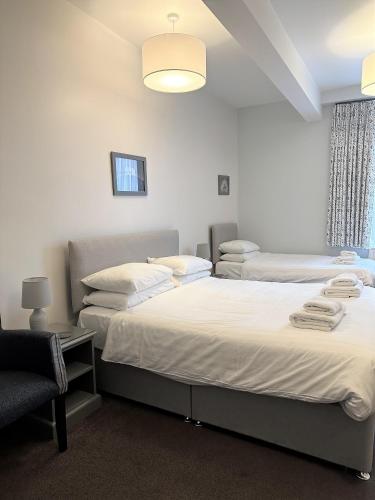 a bedroom with two beds and a chair in it at The Bar Convent Guest House in York