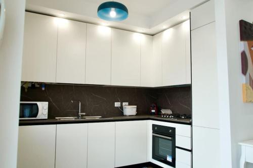a white kitchen with a sink and a microwave at Residenza dei Molini Monza centro in Monza