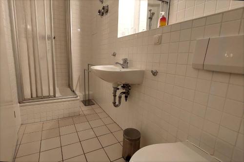 a white bathroom with a sink and a toilet at Haus Baltic Sellin by Rujana in Ostseebad Sellin