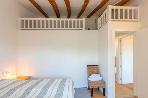 ein Schlafzimmer mit einem Bett und einem Stuhl in der Unterkunft Mas Tinus - Palmera in Santa Cristina d'Aro