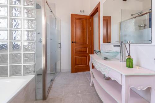 y baño con lavabo de cristal y ducha. en Mas Tinus - Lavanda, en Santa Cristina d'Aro
