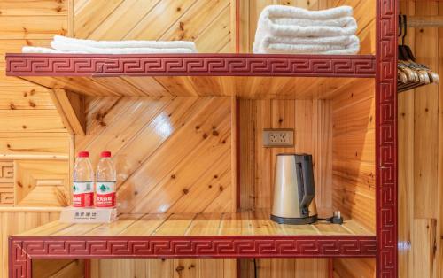 a wooden cabin with a coffee maker and towels at Baike Boutique Hotel in Longsheng