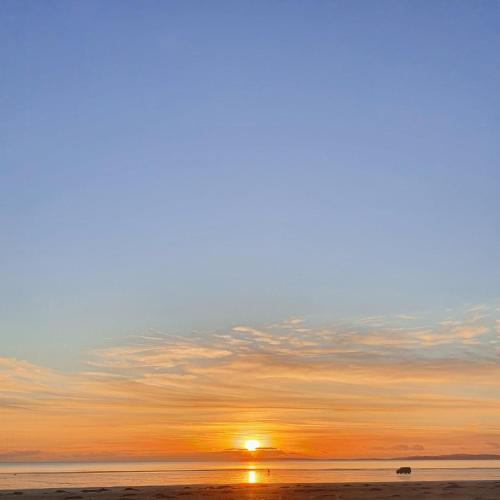 a sunset on the beach with the sun setting at apartment porthmadog harbour side fantastic views in Porthmadog