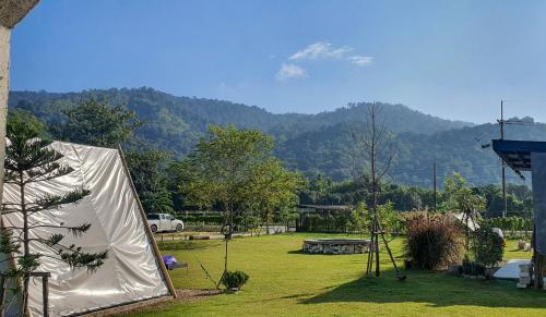 a tent in a yard with mountains in the background at Take Time Nature Resort in Ban Tha Sai