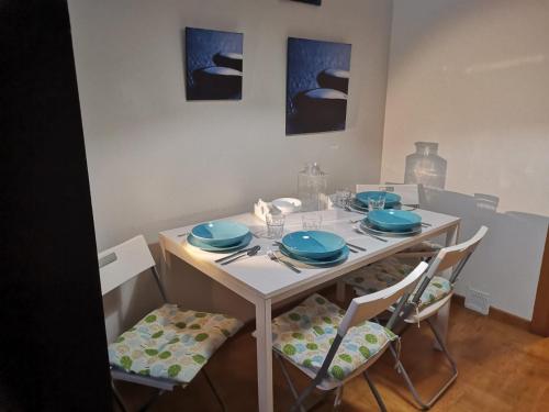 a dining room table with blue plates and chairs at Apartamento Llanes Mar y Monte in Llanes