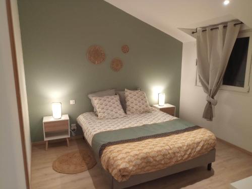 a bedroom with a bed with two lamps on it at Cottage neuf - Forêt de Tronçais in Urçay