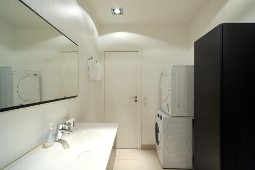 a white bathroom with a sink and a refrigerator at Spacious Flat Centrally Located in CPH's Old Town in Copenhagen