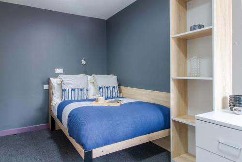 una camera con letto e pareti blu di For Students Only Cosy Private Ensuites in Warwick a Coventry