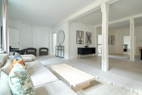 a white living room with a couch and a table at Spacious Flat Centrally Located in CPH's Old Town in Copenhagen