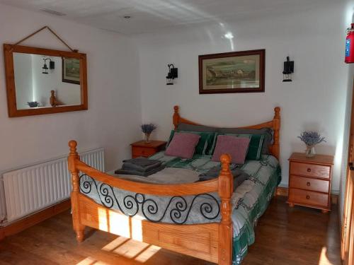 a bedroom with a wooden bed in a room at Eddie's Roadside Thatched Cottage 