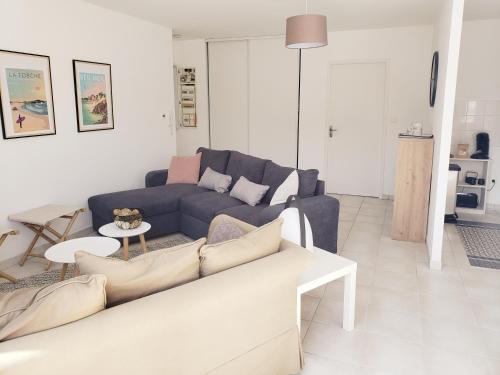 un salon avec un canapé bleu et une table dans l'établissement L' ESCAPADE MARINE dans la station balnéaire de Beg-Meil (Fouesnant), à Fouesnant