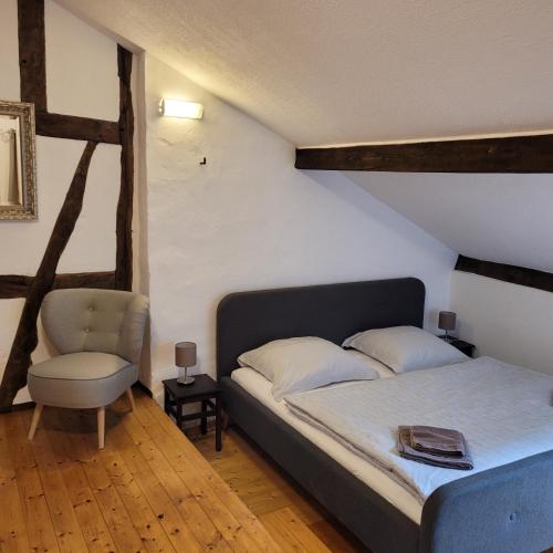 a bedroom with a bed and a chair at Alter Posthof Lieser in Lieser
