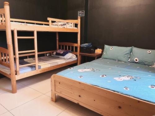 東港的住宿－前寓民宿，一间卧室配有两张双层床和一张蓝色的床。