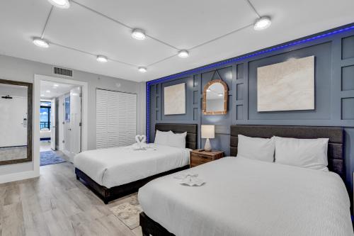 two beds in a bedroom with blue walls at Breakers Tower 1BR Oceanfront Condo in Myrtle Beach