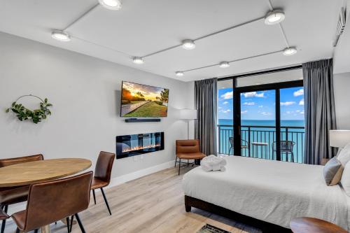 a bedroom with a bed and a table and a dining room at Breakers Tower 1BR Oceanfront Condo in Myrtle Beach