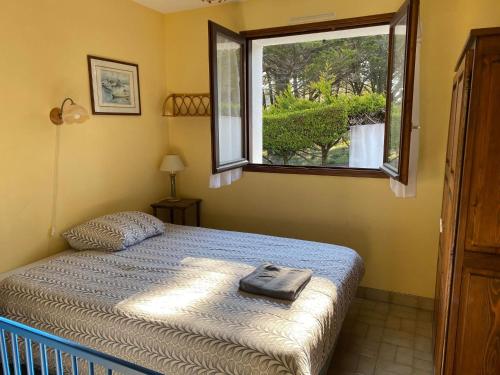 a bedroom with a bed and a window at MAISON 3 CHAMBRES SUR UNE DUNE A 50 M DE LA PLAGE in La Tranche-sur-Mer