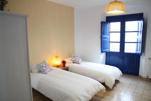 two beds in a room with a window and a lamp at Apartament - COMPARTIR in Cadaqués