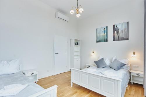 a white bedroom with two beds and white cabinets at WISUS 24 in Świnoujście