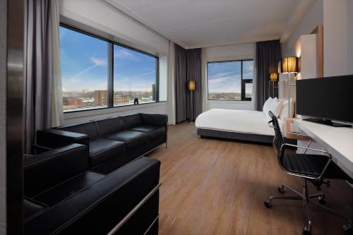 a hotel room with a bed and a couch at WestCord WTC Hotel Leeuwarden in Leeuwarden