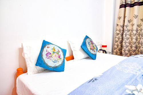 Duas camas num quarto com almofadas azuis e brancas em Lava Hotel Aashiyana em Lava