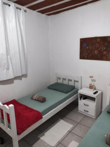 een kleine slaapkamer met een bed en een tafel bij Hospedagem Progresso in Juiz de Fora