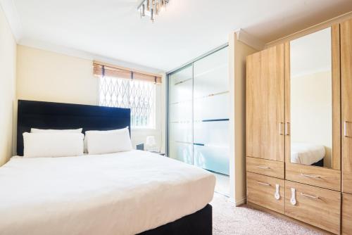 a bedroom with a large bed and a large closet at Austin David Apartments - Hendon Pad in Hendon